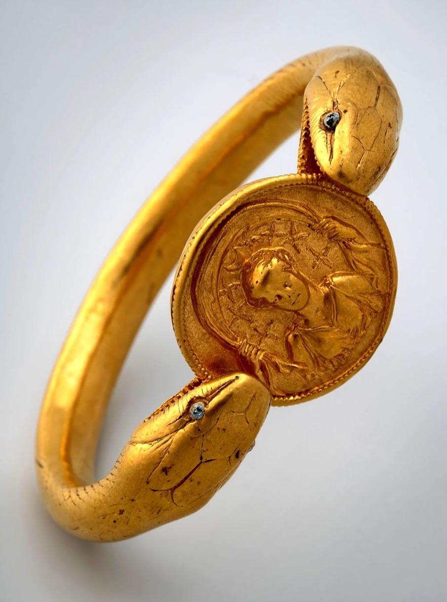 A gold bracelet found on a woman who died during the eruption of Mount Vesuvius in Pompeii in 79 AD. It is shaped like a two-headed snake with glass eyes, holding a medallion of th